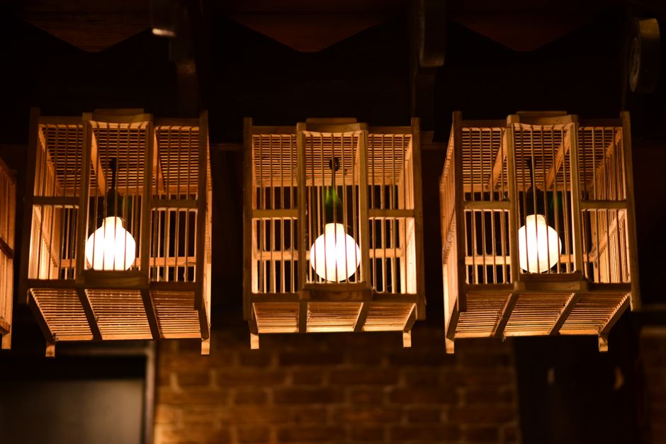 Hangende geweven rieten lamp boven rustieke tafel. Hangende geweven rieten lamp boven rustieke tafel.